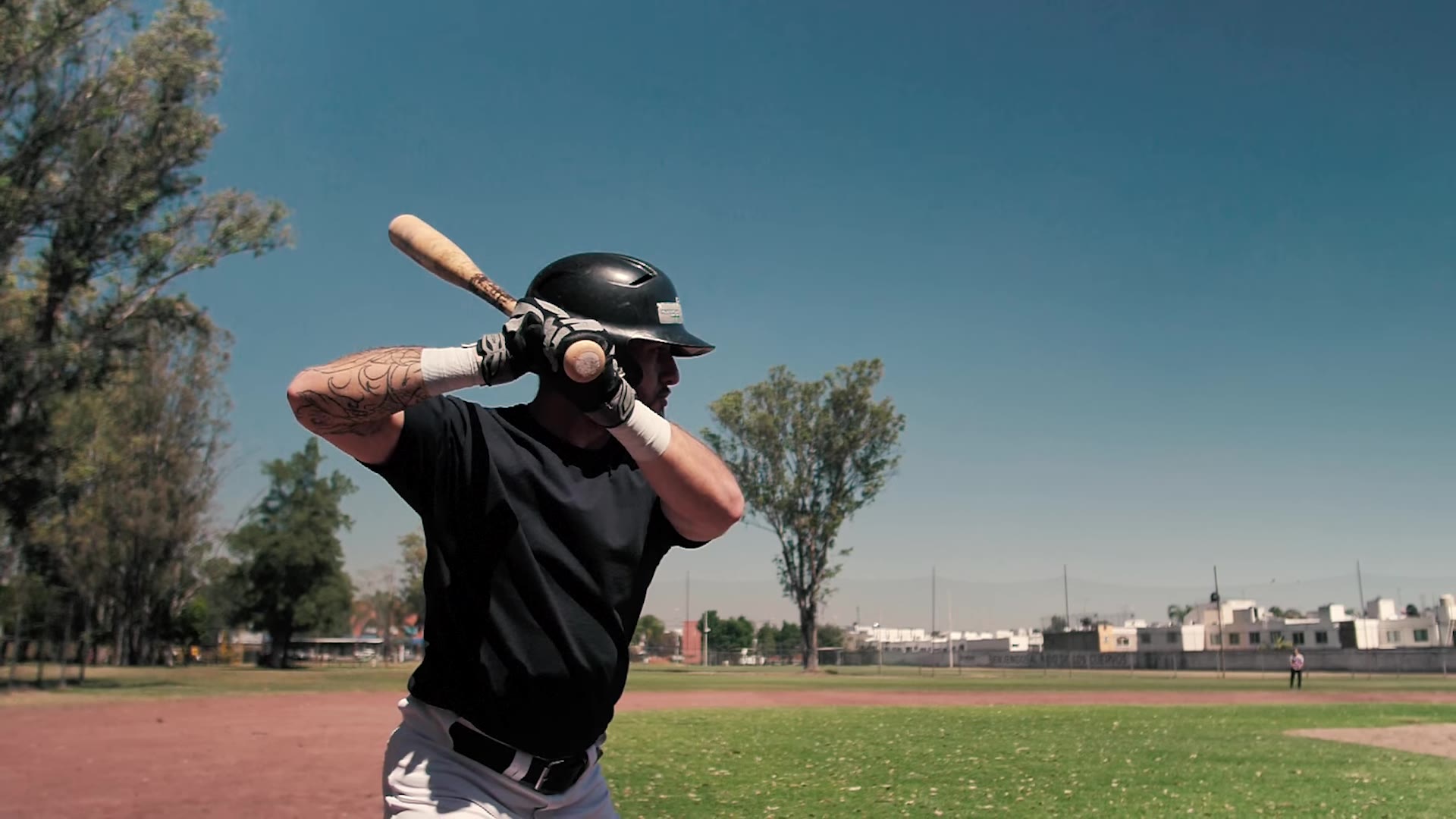Baseball batter preparing for a practice swing on an outdoor field